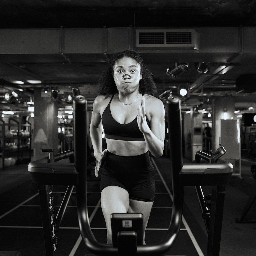 Woman exercising on a running machine in a gym.