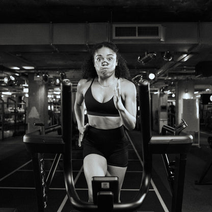 Woman exercising on a running machine in a gym.