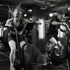 Two people exercising on stationary bikes in a gym setting.