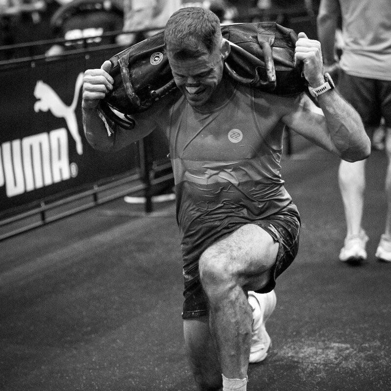 Person lifting a sandbag with a Puma logo in the background