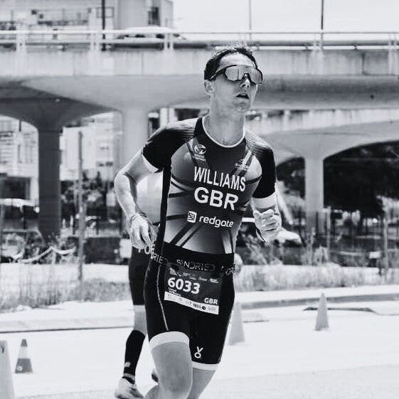 Person in a triathlon suit running outdoors with urban background